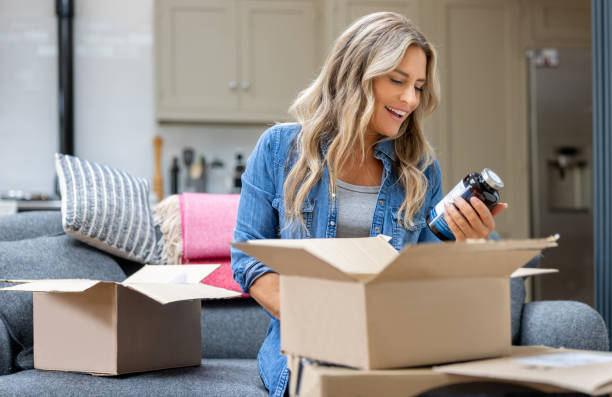 Happy woman opening a package at home after shopping online.